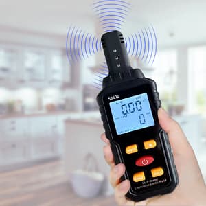 Handheld digital EMF meter with LCD display showing electromagnetic field readings and temperature